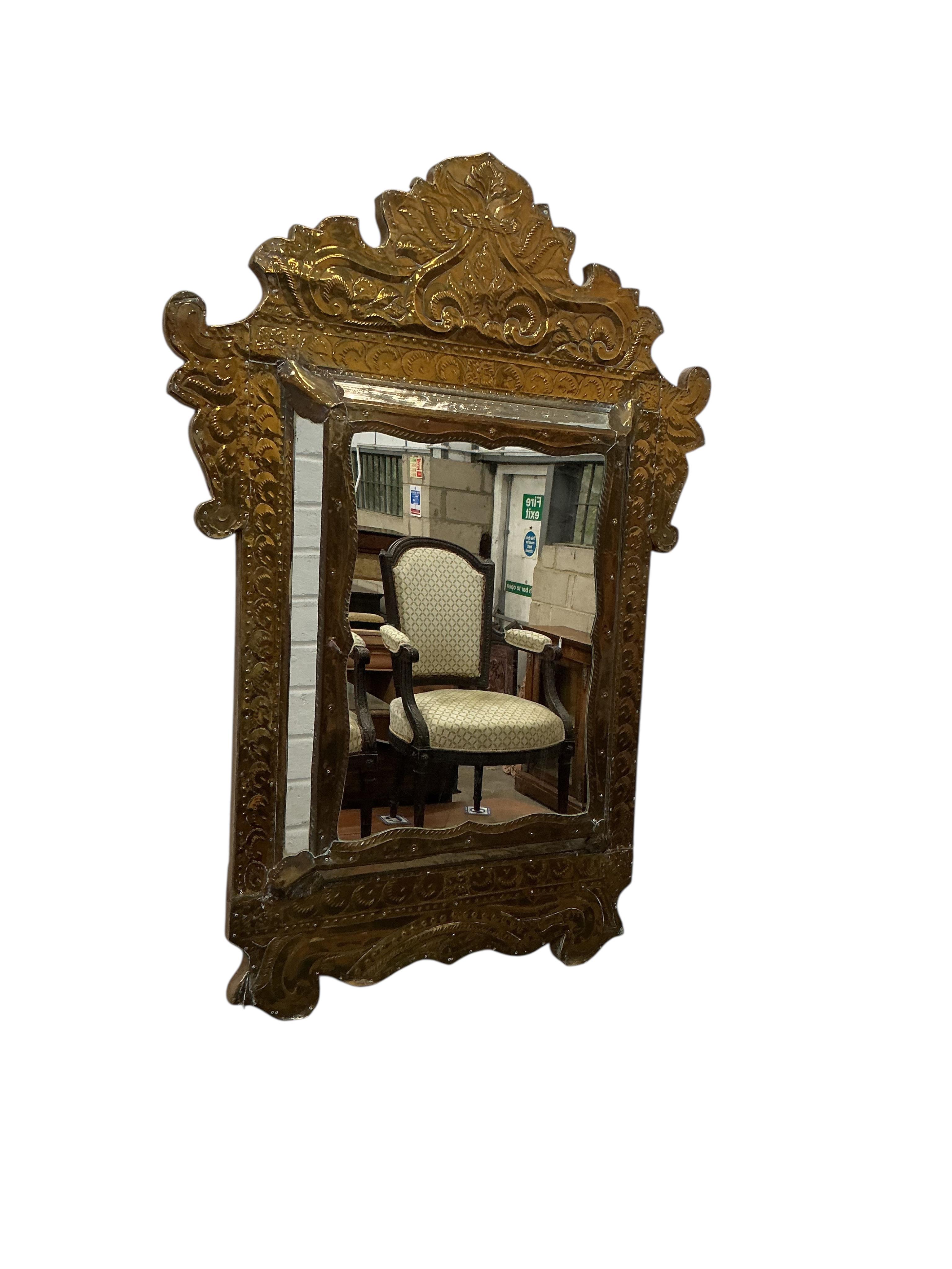 A pair of Eastern embossed brass wall mirrors, width 57cm, height 82cm